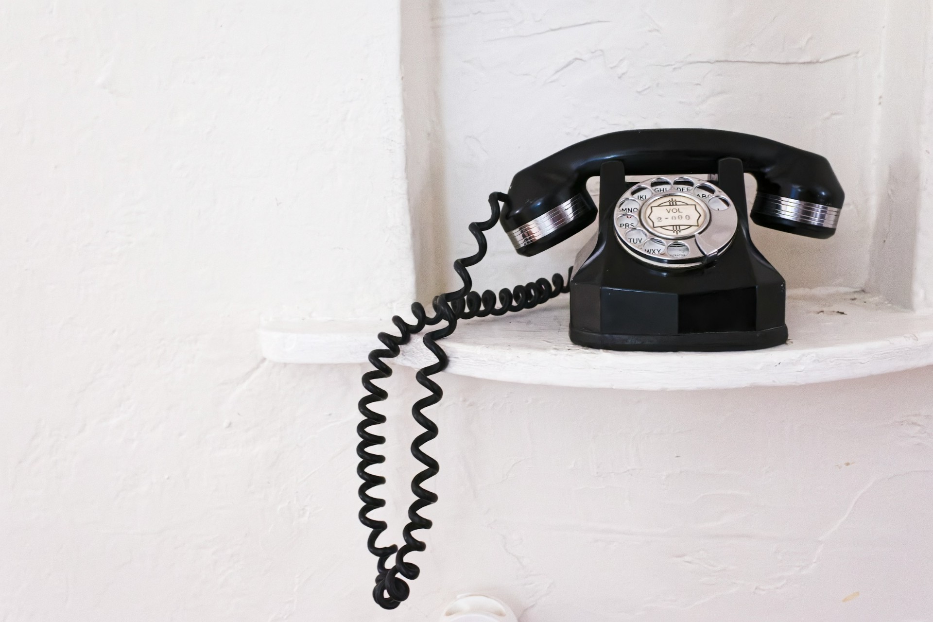 Vintage rotary phone on a white shelf